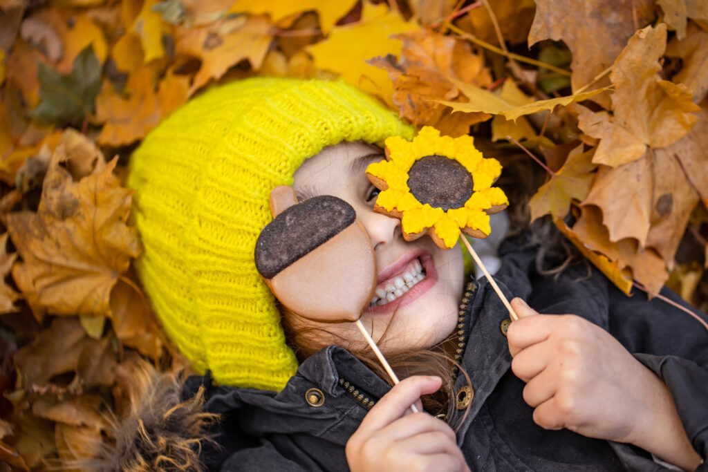 Fillette souriant dans les feuilles d'automne